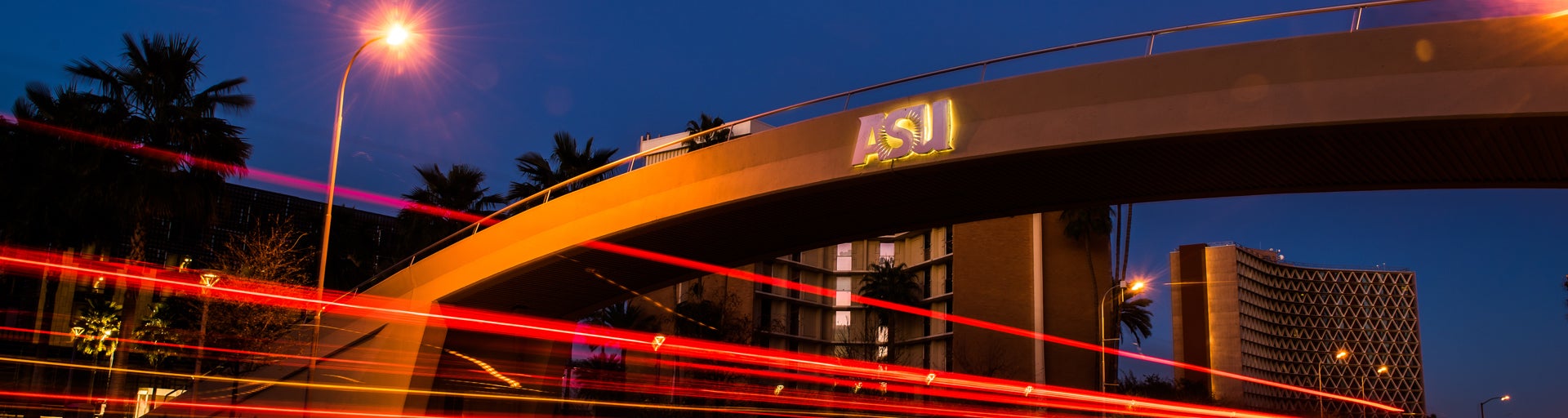 A bridge displaying the ASU logo at dusk