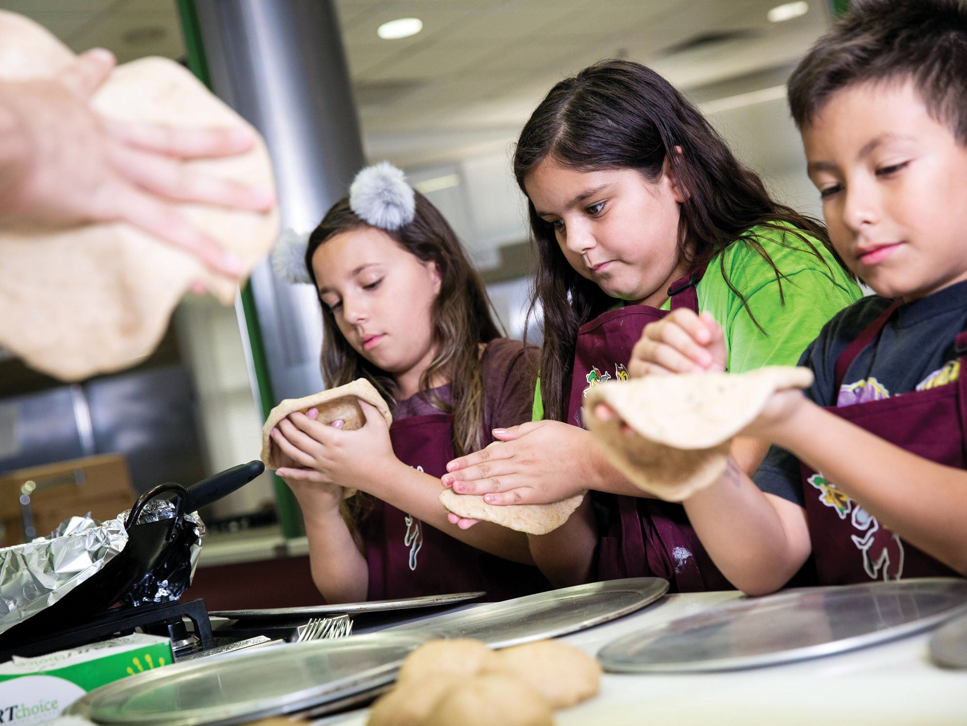 Children make tortillas in an ASU kitchen