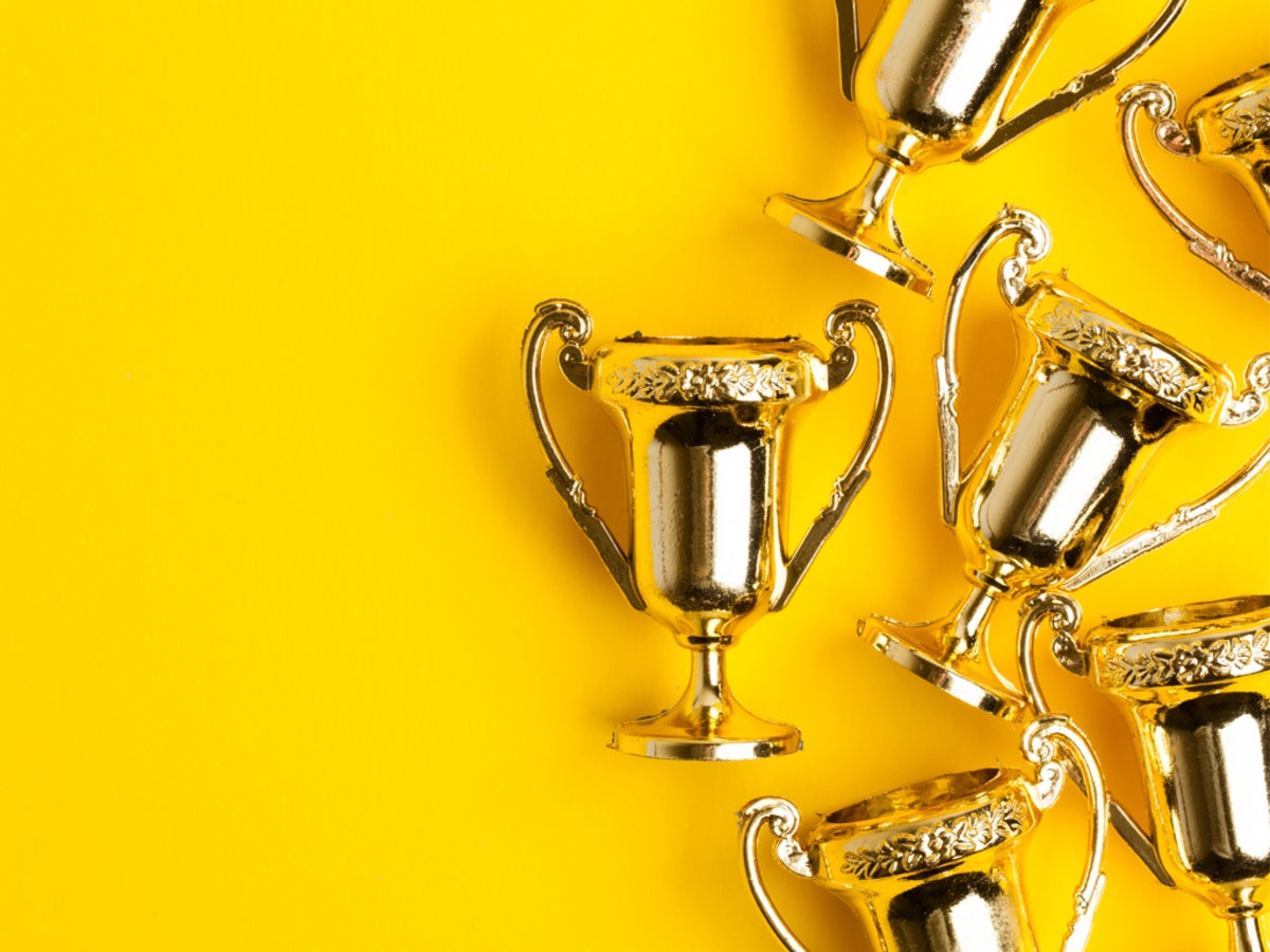 Gold trophies on a yellow background.